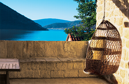 Island setting with kubu hanging chair on balcony looking over ocean